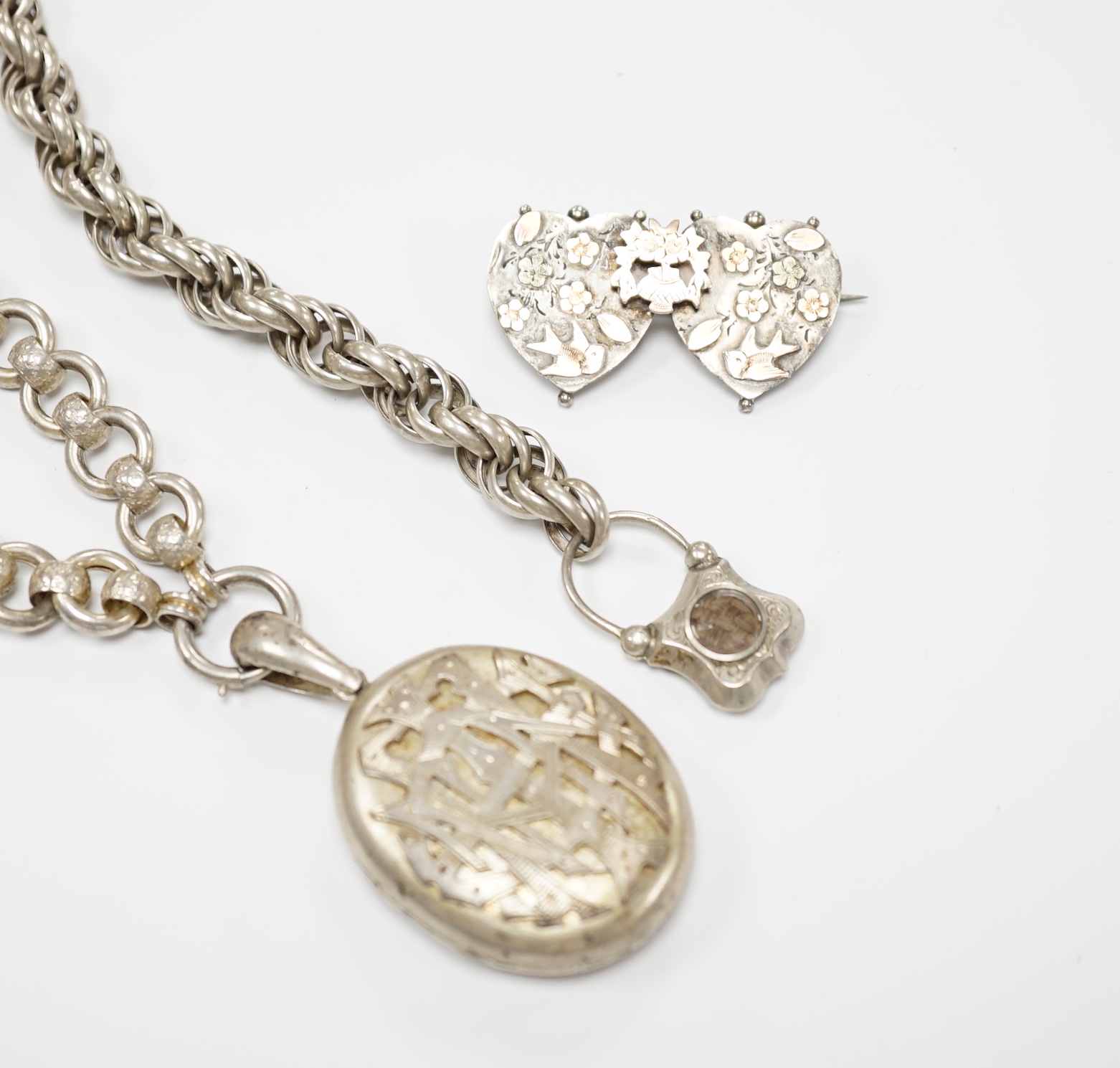 A Victorian white metal chains with a locket, a white metal bracelet and a sterling double heart shaped brooch.